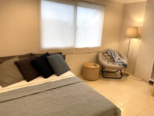 奥隆阿波CRIB 227: Modern Fresh Vibe Condo的卧室配有床、椅子和窗户。