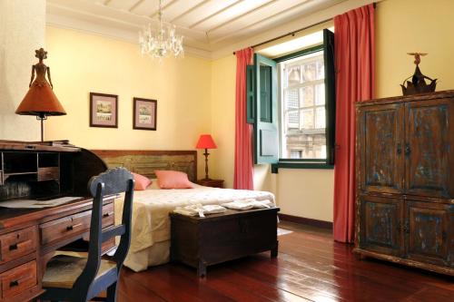 萨尔瓦多巴伊亚别墅酒店的一间卧室配有一张床、一张书桌和一张书桌