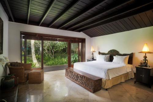 乌布Villa Puri Tupai的一间卧室设有一张大床和一个大窗户