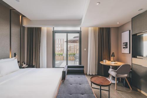 宁波宁波集士港奥特莱斯亚朵酒店的酒店客房配有一张床铺和一张桌子。