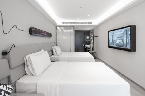 南京南京农业大学轻居酒店的酒店客房设有两张床和一台平面电视。