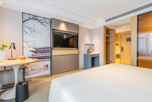 西安西安胡家庙地铁站亚朵酒店的酒店客房设有一张大床和一台电视机。