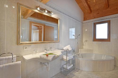 菲根考斯腾泽公寓的一间带水槽、浴缸和镜子的浴室
