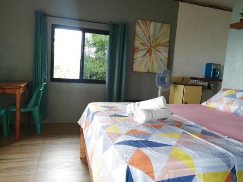 锡基霍尔Shambala Paradise的一间卧室配有一张带五颜六色的被子的床和窗户
