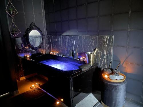 MaingLa Suite Maléfik的浴室配有带灯的浴缸。