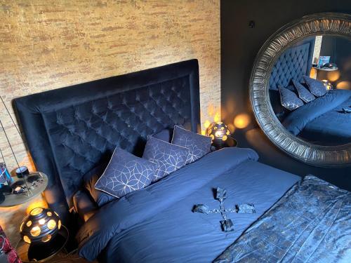 MaingLa Suite Maléfik的一间卧室配有蓝色的床和镜子