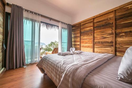 麦岛Hidden Beach Resort的一间卧室设有一张大床和一个大窗户