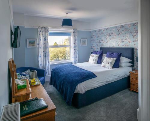 多切斯特Aquila Heights Guest House的一间卧室设有蓝色的床和窗户。