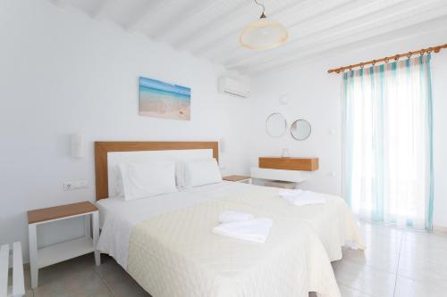 奥诺斯Cyclades Blue的白色卧室配有带2条毛巾的床