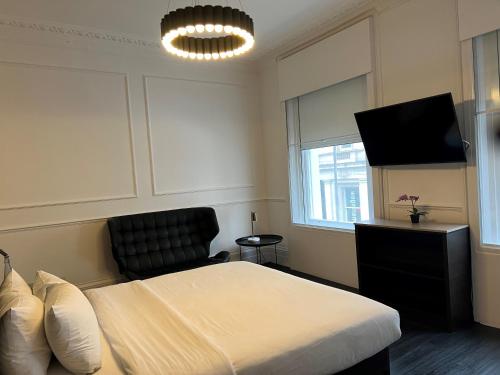 伦敦The Z Hotel Covent Garden的一间卧室配有一张床和一台平面电视