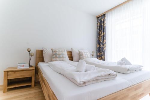 韦尔特湖畔克伦彭多夫Apartments Oasis Wörthersee neu & zentral的卧室设有两张床,配有白色床单和窗户。