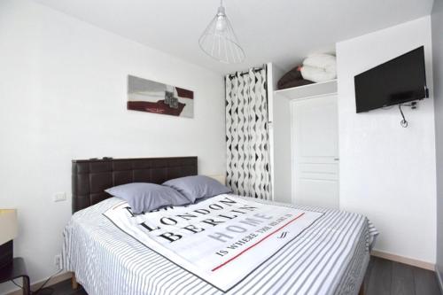 勒卡内Le Cannois的一间卧室,配有一张带标志的床