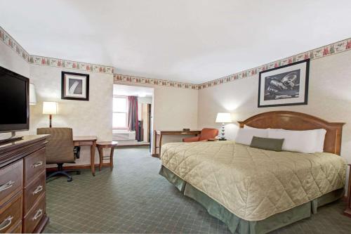 弗莱明顿夫雷明华美达酒店的配有一张床和一张书桌的酒店客房