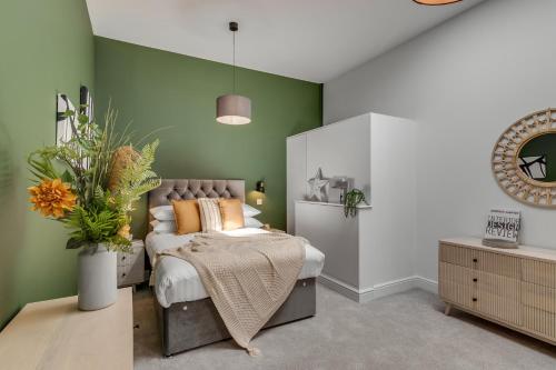 SnettertonFen Lane Lodge的一间卧室设有一张床和绿色的墙壁