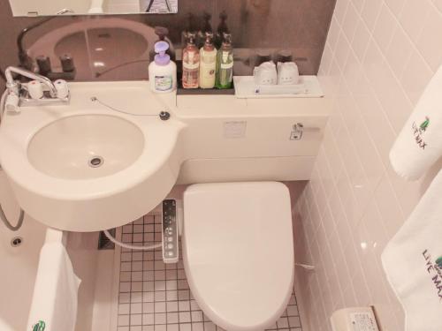 京都HOTEL LiVEMAX Kyoto Ekimae的浴室配有白色卫生间和盥洗盆。