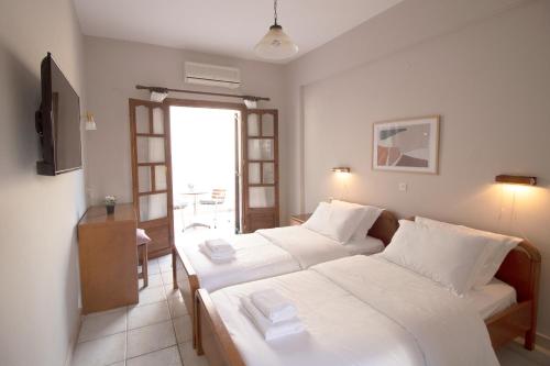帕尔加Pomelo Rooms的酒店客房设有两张床和窗户。