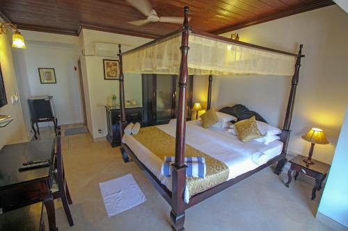 坎多林科凯拉尔度假酒店的一间卧室配有一张天蓬床和一张书桌