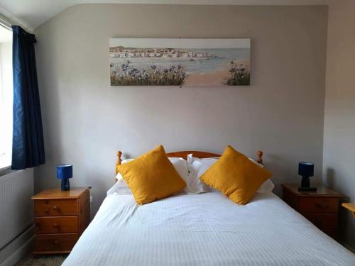 诺里奇The Bell Inn的一间卧室配有一张带两个黄色枕头的床