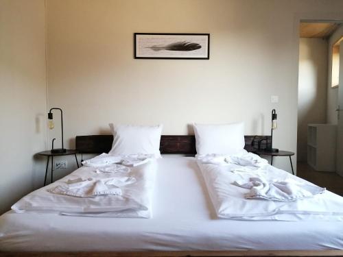 卢塞恩Easy-Living Kriens Apartments的一张白色大床,配有白色床单和枕头