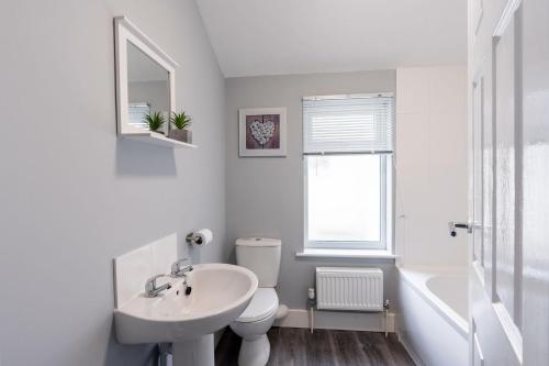 格里姆斯比Modern & Beach Location & Contractors & Leisure & Garden的白色的浴室设有水槽和卫生间。