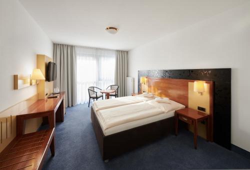 斯图加特万森斯塔德酒店的酒店客房设有一张大床和一张书桌。