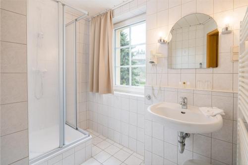 诺伊豪森Landhaus Purschenstein的白色的浴室设有水槽和淋浴。