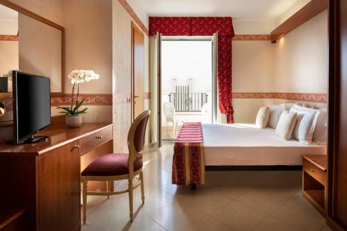 里米尼加丽雅皇宫酒店的酒店客房,配有床和电视