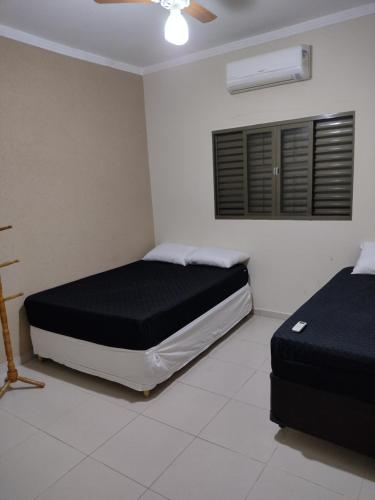 奥林匹亚Recanto Cote Gil的一间卧室配有两张床和吊扇
