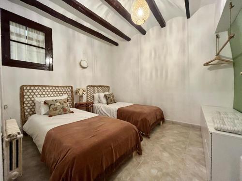 勃朗峰Cal Pere de L'Onclet的白色墙壁客房的两张床