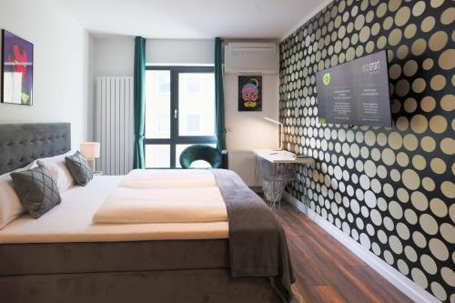 纽伦堡Eco Smart Apartments Premium City的一间卧室配有一张床,墙上配有电视