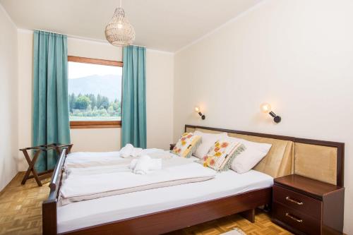法克湖Ferienhaus Faakersee Hideaway am See的一间卧室设有一张大床和一个窗户。