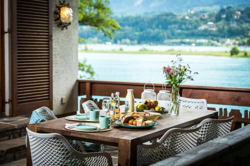 法克湖Ferienhaus Faakersee Hideaway am See的一张木桌,上面有盘子的食物