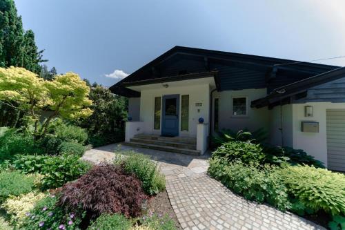 沃尔特湖畔韦尔登Ferienhaus Karawankenblick Velden的一座带蓝色门和一些植物的房子