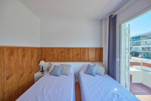 马盖鲁夫Nura Houses Apartment Magaluf 3的一间卧室设有两张床和大窗户