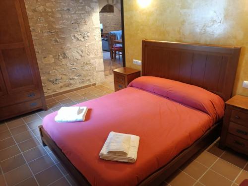 CastellfortCasa Els Arcs的一间卧室配有一张带红色床单和镜子的床