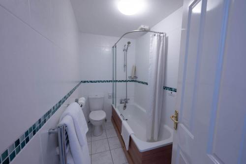 Hugh Town崔格森酒店的带浴缸、卫生间和淋浴的浴室。