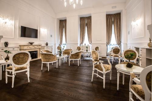 布达佩斯布达佩斯威望酒店的客厅配有桌椅和电视