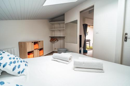 拉特斯特德布赫LA FORESTIERE - Petit havre de paix au Pyla, face aux pins的卧室配有白色的床和2条毛巾