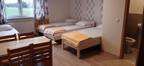 WroceńNoclegi nad Biebrzą Stara Szkoła的小房间设有两张床和一张桌子
