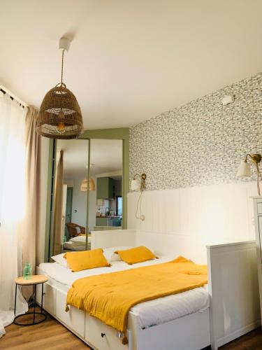 圣地亚哥－德孔波斯特拉La Casita del Patio的一间卧室配有一张带黄色床单和镜子的床