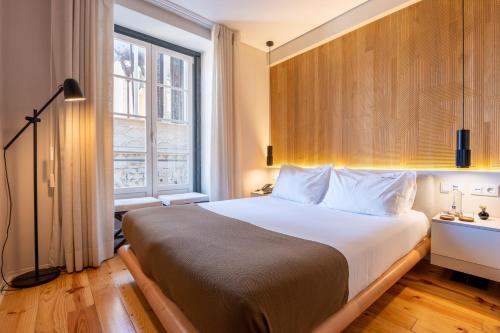 里斯本Tempo FLH Hotels Lisboa的一间卧室设有一张大床和一个窗户。