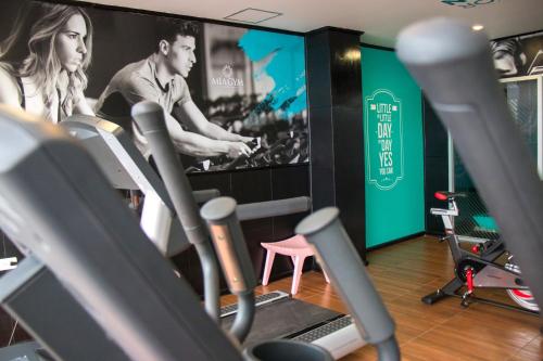 比亚埃尔莫萨Mia City Villahermosa的健身房设有有氧器材和大屏幕