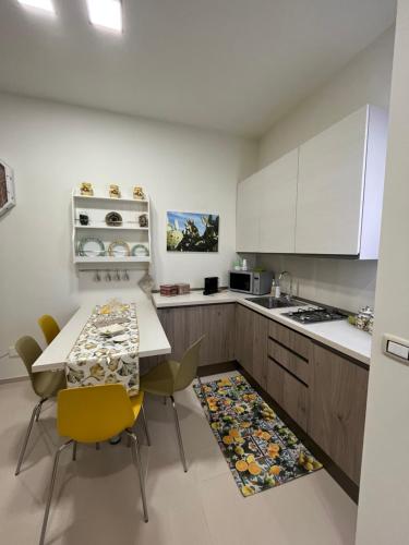 莫诺波利Casetta Mia的厨房配有白色橱柜和桌椅