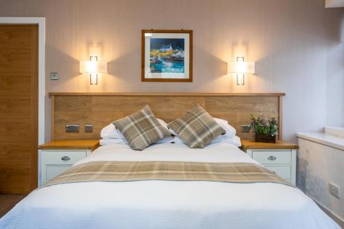 阿勒浦Riverside的卧室配有一张带两个枕头的大白色床