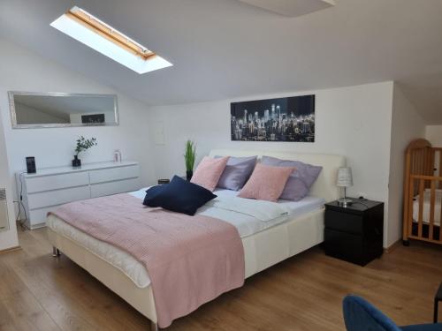 班约勒Apartman Petra s pogledom na more的卧室配有带粉红色和蓝色枕头的大型白色床