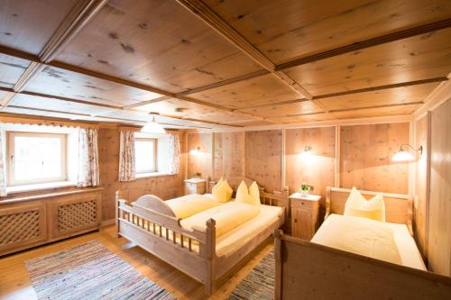 伊施格尔斯戴凡哈马特酒店的一间带两张床铺的卧室,位于带木墙的房间内