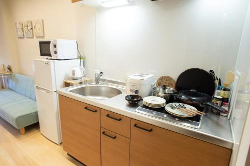 东京My Home in Tokyo - Vacation STAY 73228v的一间带水槽和冰箱的小厨房