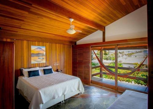 萨夸雷马Oceanica 1000 Beachfront Suites的一间卧室设有一张床和一个大窗户