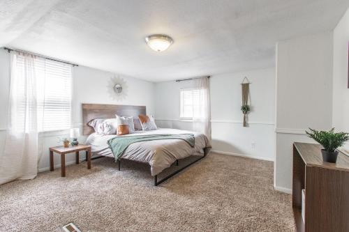 堪萨斯城3 Bedrooms House in Waldo Kansas City的白色卧室配有床和桌子