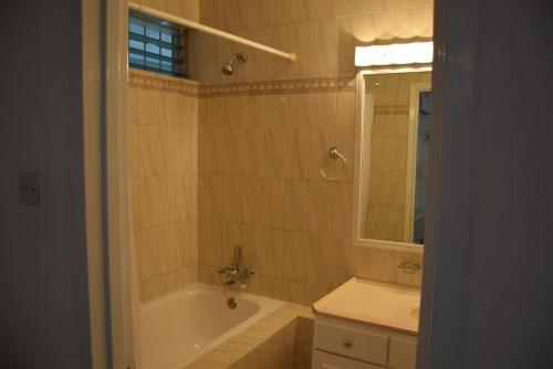 圣詹姆斯Goldenview的带浴缸、水槽和镜子的浴室